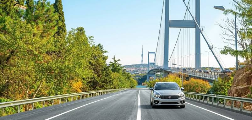 Compact car parked along a scenic coastal road representing cheap car rental Turkey travel options