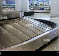 A rotating black rubber airport baggage claim carousel ...