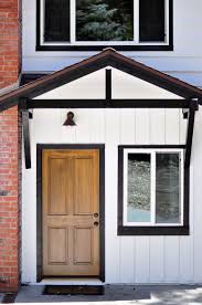 Black And White House With Wood Door Lake House Update Exterior Before After Lake Houses Exterior House Exterior Black Window Trims
