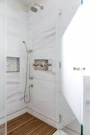 A Polished Nickel Shower Kit With A Sprayer Is Fixed To Large White Marble Wall Tiles Over A Teak Slatted Floor An Teak Shower Floor Teak Bathroom Shower Floor