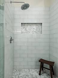 A Chrome Shower Kit Is Fixed To Gray Glass Shower Wall Tiles Over Gray Hexagon Floor Tiles As A Teak Bench Sits In 2020 Shower Wall Tile Glass Shower Wall Shower Wall