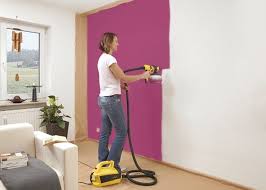 Woman Painting Interior Wall With Wagner Paint Sprayer Interior Wall Paint Paint Sprayer Indoor Paint