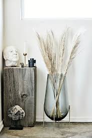 Natural Pampas Grass In A Tall And Modern Clear Blue Vase On A Gold Stand Will Perk Up Just Decorating My First Apartment Trending Decor Home Decor Accessories
