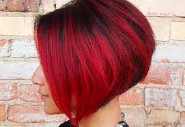 Low angle view of beautiful redhead young woman standing on grey with gradient. Red And Black Hair Ombre Balayage Highlights