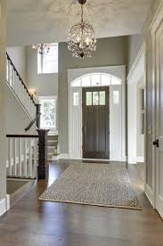 Foyer With A Hardwood Flooring And A Rug Along With Gray Walls Lighted By A Charming C Foyer Lighting Foyer Lighting Fixtures Foyer Lighting Fixtures Entryway