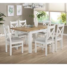 A table has a rectangular top, 2 wide supports, racks for plastic bins. White Oak Extendable Dining Set With 6 White Dining Chairs Aylesbury Furniture123