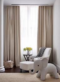 Beautiful White And Beige Nursery Boasts A Window Dressed In Sheer White Curtains Layered Behind Beige Curtains Living Room Curtains Living Room Beige Curtains