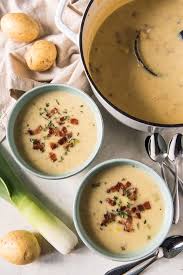 Two Bowls Of Creamy Irish Leek And Potato Soup Garnished With Crispy Bacon And Thyme Leaves Next To A Pot Of Leek Soup Potato Soup Leek Soup Crispy Bacon