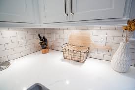 Closeup Of Quartz Countertop With White Subway Tile Backsplash New Shaker Style Doors Refinished To An Of Cabinet Molding Cabinet Trim Under Cabinet Lighting