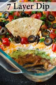 The Best 7 Layer Dip Made With Seasoned Refried Beans Guacamole Sour Cream Cheese Olives Tomatoes And Cookout Food Layered Bean Dip Mexican Food Recipes