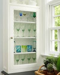 Chic country kitchen boasts upper cabinets, with backs of shelves lined with gray damask wallpaper, accented with chicken wire doors. Chicken Wire Mesh Cabinets