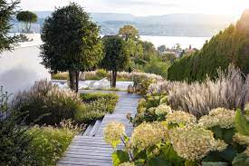 Blickt Man Vom Oberen Hauseingang Zum See Hinunter Scheinen Die Grenzen Zwischen Garten Und Landschaft Zu Versc Bepflanzung Gartengestaltung Garten Bepflanzen