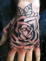 Grey And Black Rose Tattoo On Left Hand Rose Hand Tattoo Hand Tattoos For Guys Traditional Rose Tattoos
