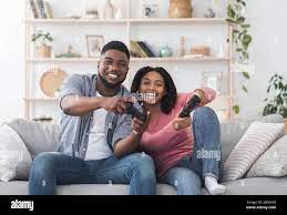 Cheerful black couple having fun at quarantine, competing in video games  Stock Photo - Alamy