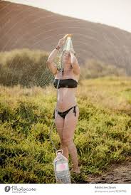 Angenehme Frau im Badeanzug beim Duschen auf dem Feld - ein lizenzfreies  Stock Foto von Photocase