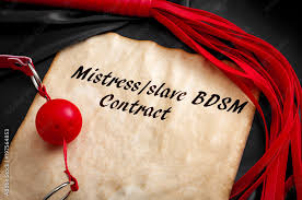 BDSM contract or “slave contract” concept with sex toys, ball gag and a  flogger around an old piece of paper with the text 