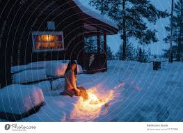 Nackte Frau, die am Feuer im Schnee sitzt. - ein lizenzfreies Stock Foto  von Photocase