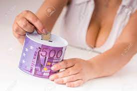 巨乳の女の子は貯金箱にコインを入れ の写真素材・画像素材. Image 44017132.