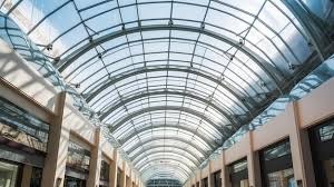 A Glass Roof In A Mall With A Blue Sky