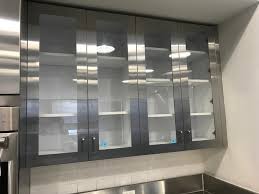 Four Stainless Steel Glass Front Cabinets
