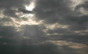 sun beams through a dark cloudy sky