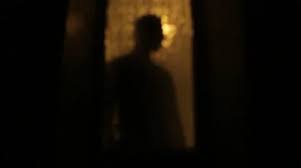 Silhouette Of Man Behind A Glass Door