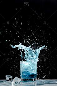 An Ice Cube Creates A Splash In A Glass