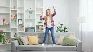 Dynamic Girl Jumping On Cozy Sofa Of