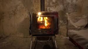A Fire In A Camping Stove With A Glass