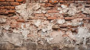 Decrepit Wall Showcasing Exposed Brick