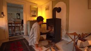 Man Starting Fireplace In Old Cottage