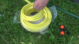 Man Unwinding Yellow Watering Hose