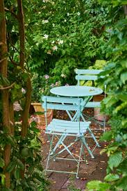 Two Green Metal Chairs And Table In A