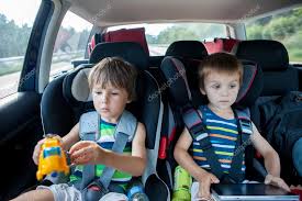 Two Boy In Car Seats Traveling In Car