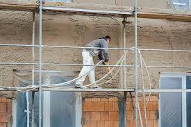 A Laborer Applying Plaster To The