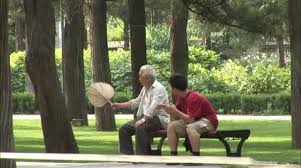 Chinese Men Talking On Park Bench