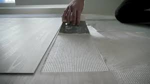 Worker Uses Scraper To Smear Glue On