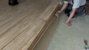 Worker Smears Glue On Concrete Floor In