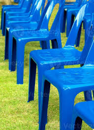 Row Of Blue Plastic Chair On Green Lawn
