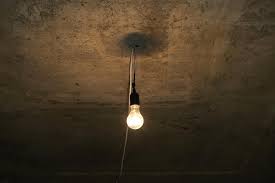 Dim Light Bulb On Concrete Ceiling
