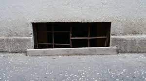 A Barred Window In The Basement In The