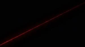 a red laser beam shines diagonally on a