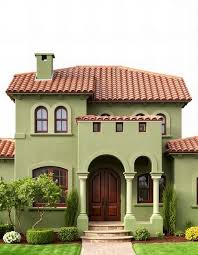 A Green House With A Red Tile Roof And