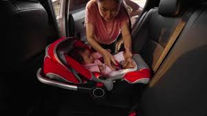 Mother Putting Infant Baby In The Car