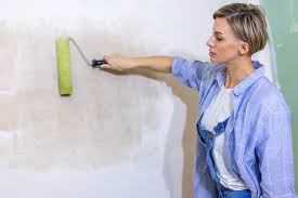 Repair Work Of Home Woman Paints Wall