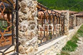 Metal Fence With Columns Of Stone And