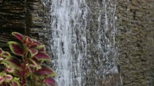 Water Flows Through Stone Wall Stock