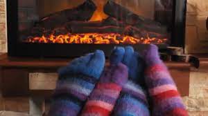 Couple Warming Feet By Fireplace At