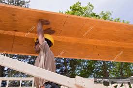 carpenter lifting a laminated beam at a