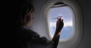 Child On Airplane In Window Seat Plays